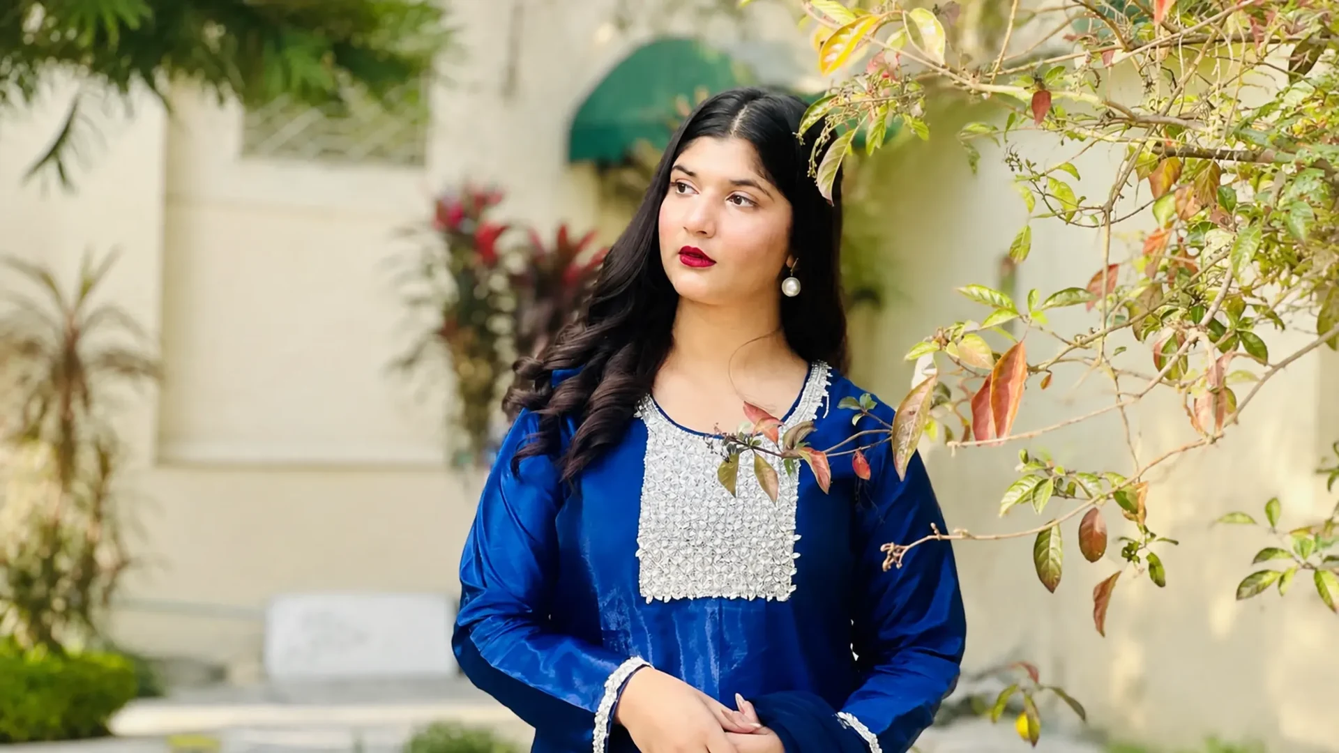 Woman wearing a royal blue outfit with detailed silver embroidery