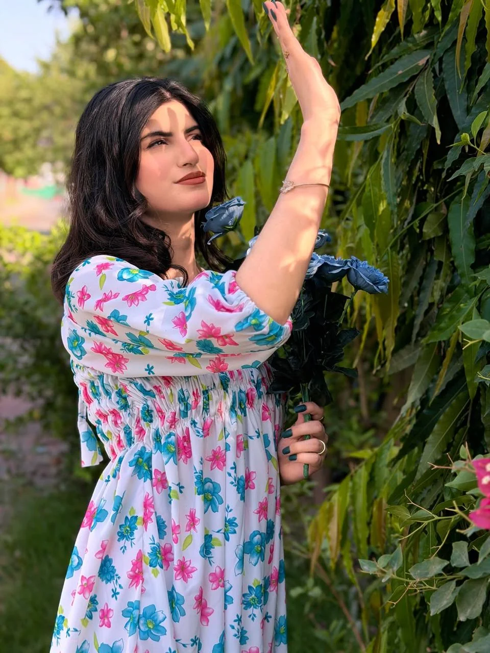 Woman wearing a white dress with pink and blue floral print